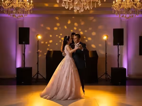Vals de padre e hija con candil y subwoofer al fondo