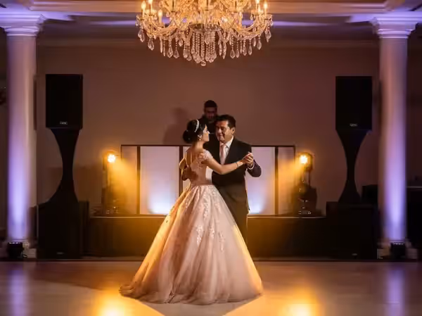 Vals de padre e hija junto a columnas de bocinas QSC