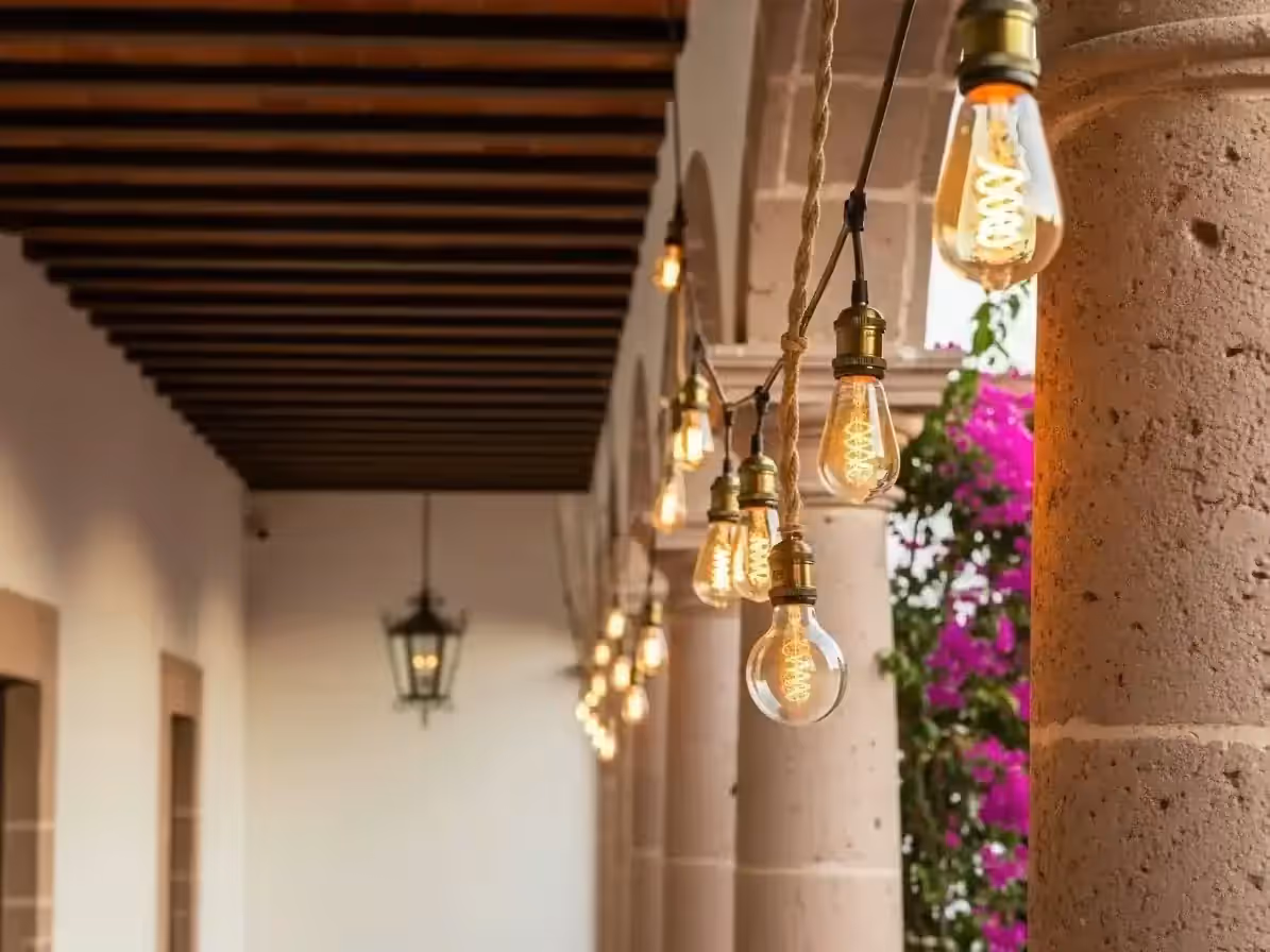 Corredor colonial iluminado con guirnaldas de focos vintage