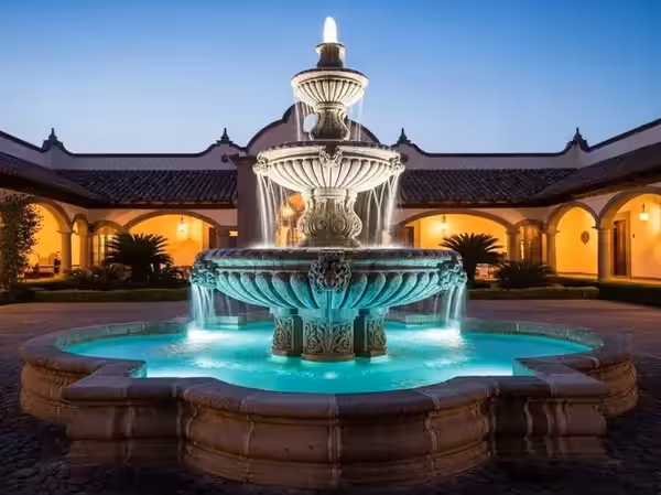 Fuente de hacienda en turquesa rodeada de jardín nocturno
