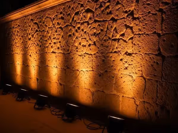 Junta por junta de un muro de piedra marcada por la luz rasante