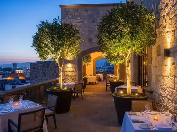Terraza mirador con árboles en luz cálida durante una cena de noche