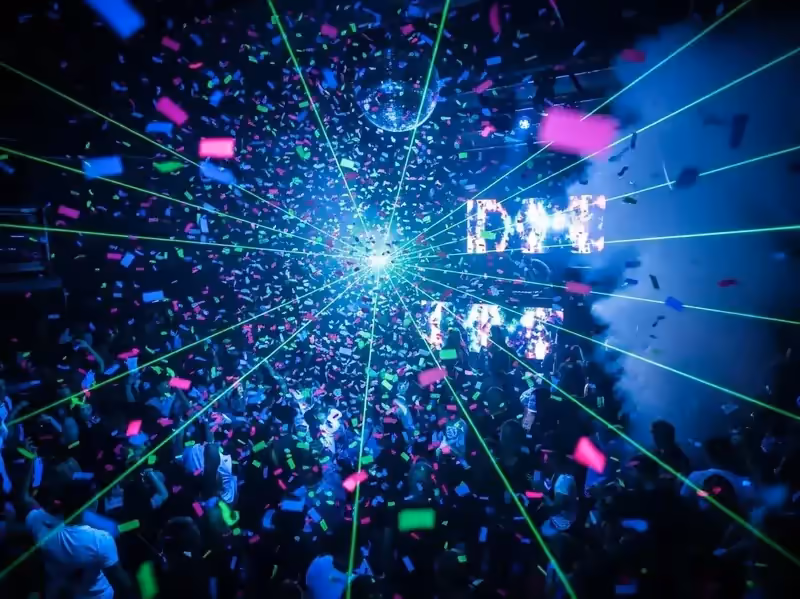Confeti en discoteca con laser verde y bola de espejos