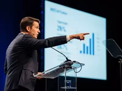 Presentación ejecutivo con podium acrílico y gráficos en pantalla azul CDMX